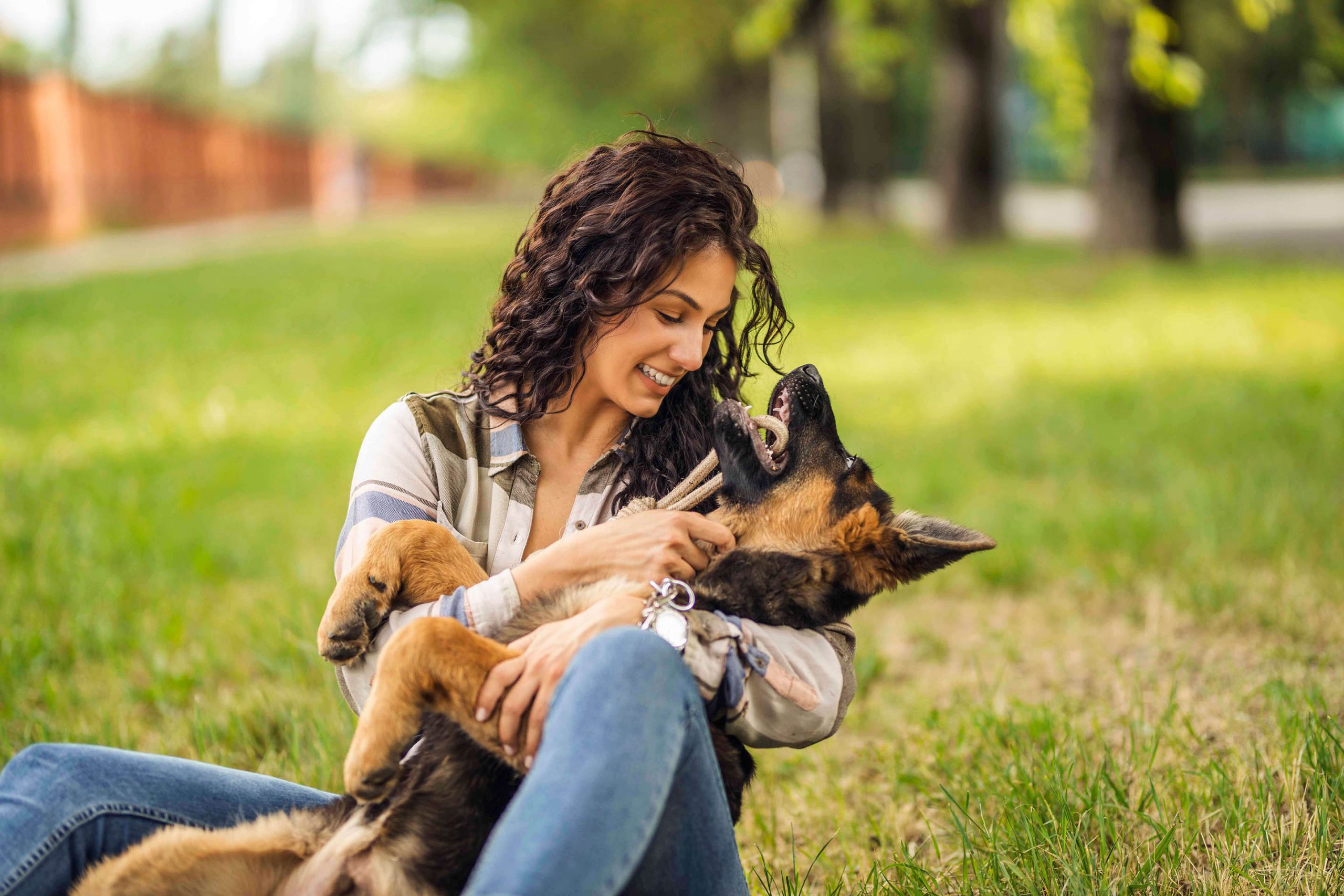 a woman playing with a German Shepherd